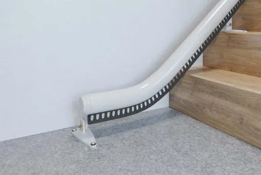 Vertical short-start drop nose rail ending on an Access Flow X, at the foot of a wooden staircase