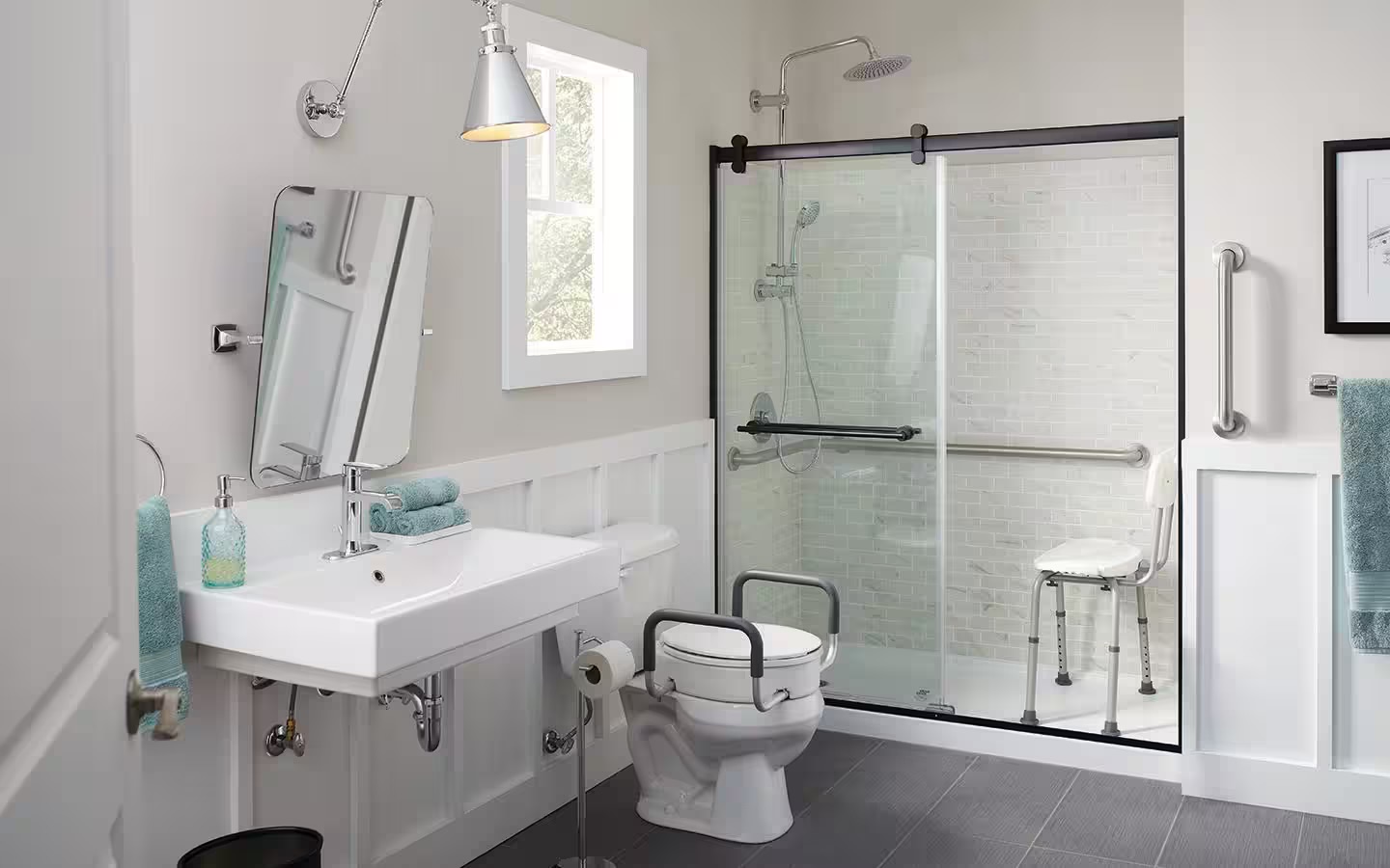 An accessible bathroom with a walk-in shower, grab bars, shower chair and raised toilet seat with rails