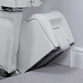 Close-up of the Handicare 1100 carriage and its enclosed travel rail, showing the drive unit under the chair