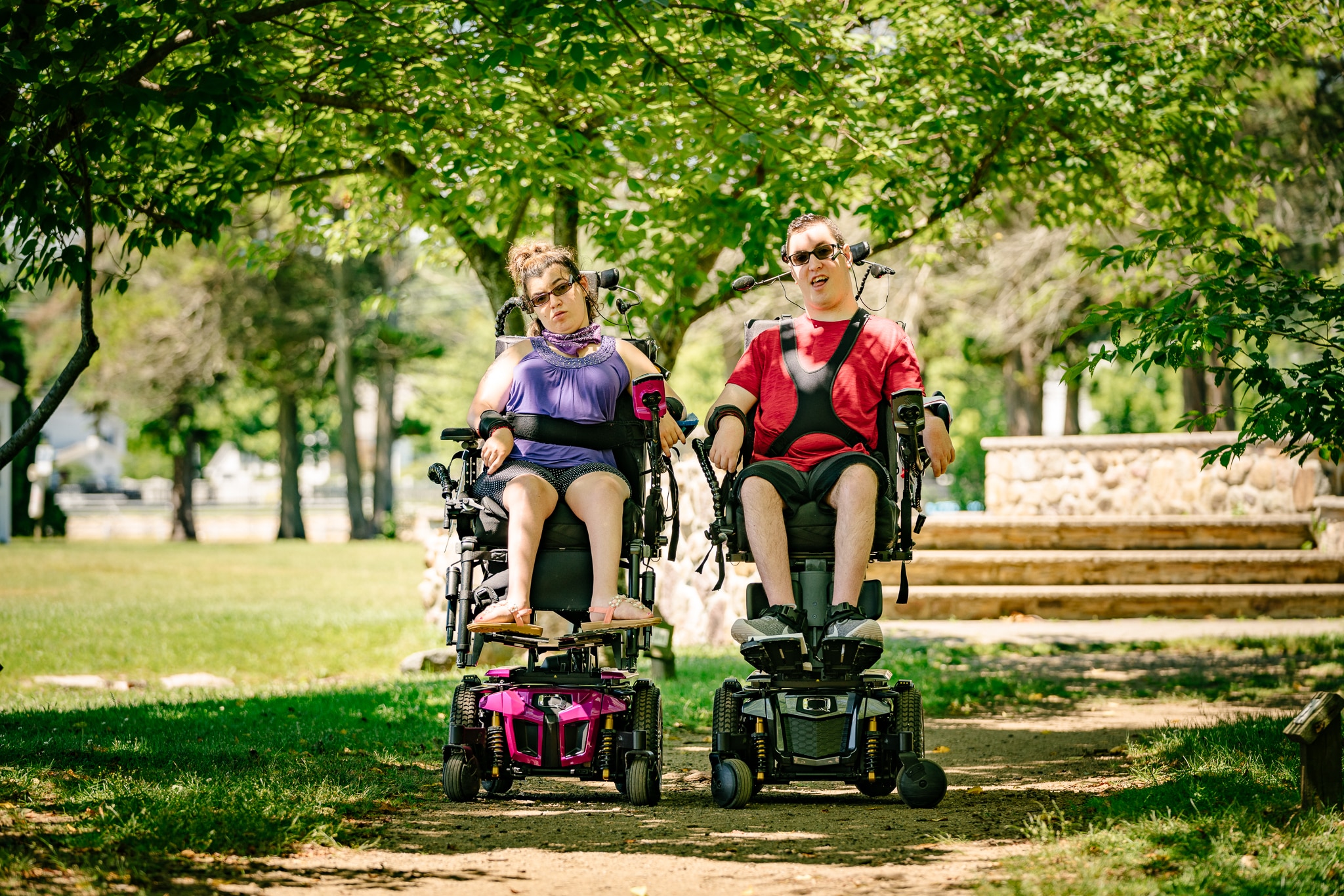 Two power wheelchair users outdoors