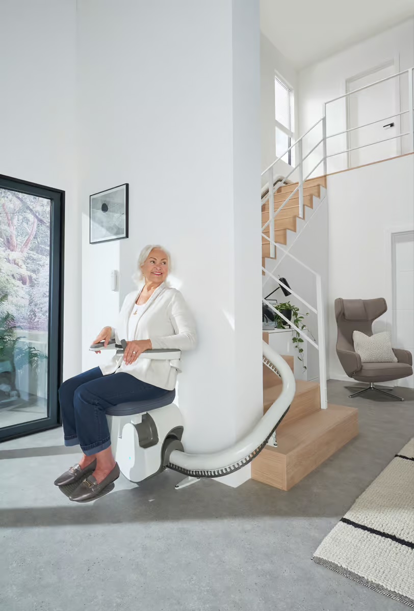 A curved stairlift rail following a turning indoor staircase