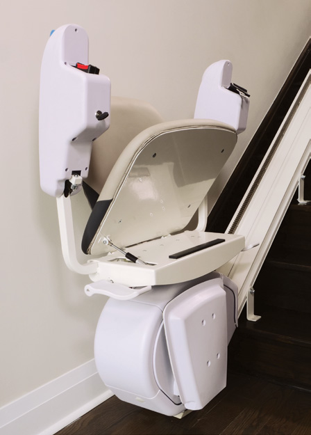 A Savaria K2 Plus chair unfolded on its rail, showing the wide seat, padded armrests and footrest